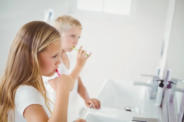 Niño y niña cepillándose los dientes —  Fotos de Stock