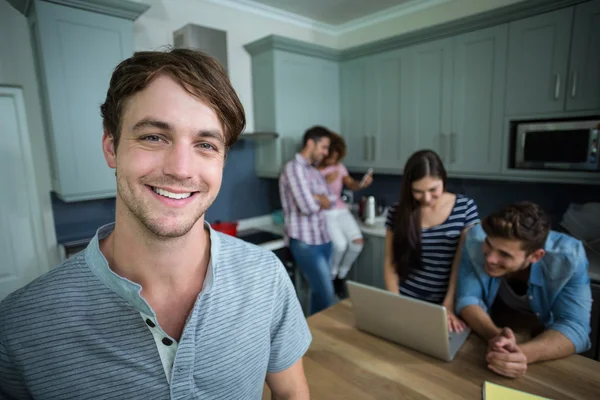 Man with friends in background at home — Stock Photo, Image