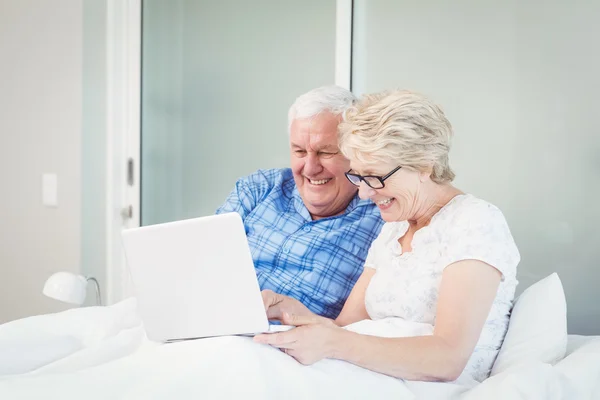 Happy couple using laptop at home — Stock Photo, Image
