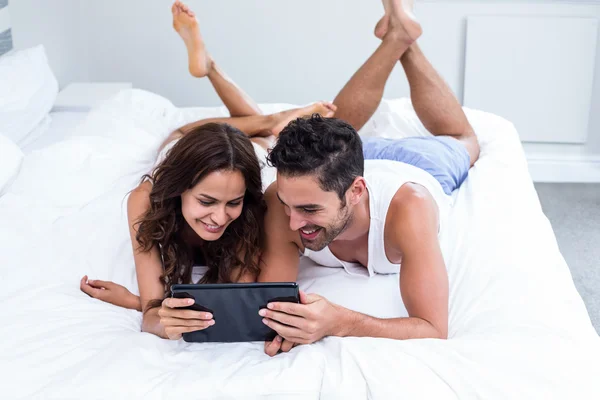 Couple using digital tablet under blanket — Stock Photo, Image