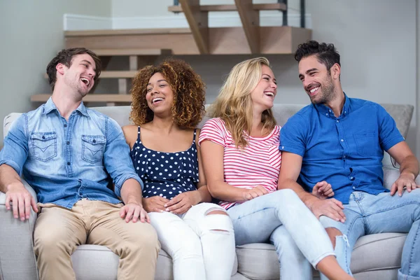 Fröhliche Freunde auf dem Sofa sitzen — Stockfoto