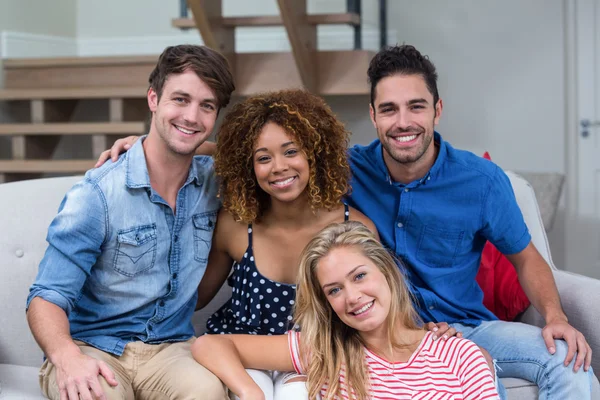 Young friends sitting on sofa — Stock Photo, Image