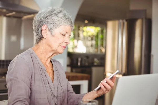 Äldre kvinna anläggning mobiltelefon — Stockfoto