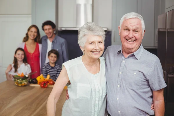 Grootouders met familie in keuken — Stockfoto