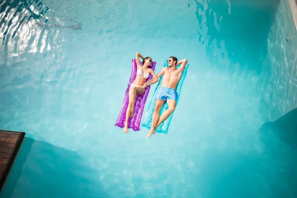 Couple relaxing on inflatable rafts — Stock Photo, Image