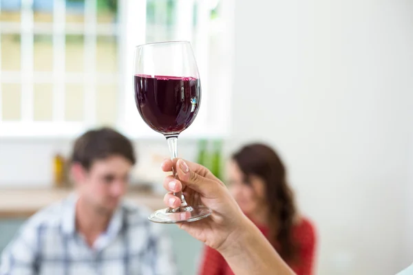 Hand som håller rött vin glas — Stockfoto