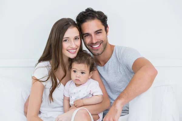 Couple with baby girl on bed — Stock Photo, Image