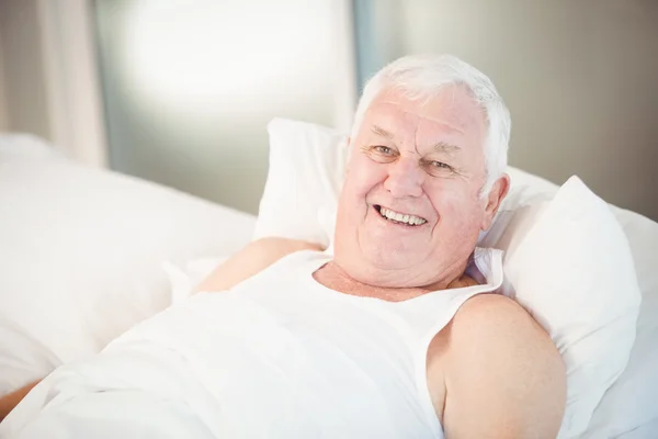 Portret starszego mężczyzny relaksującego na łóżku — Zdjęcie stockowe