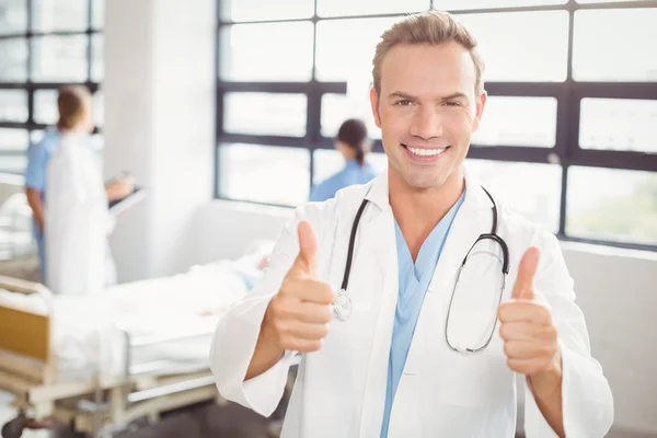 Лікар дає великі пальці вгору і посміхається — стокове фото