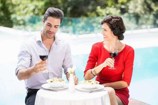 Casal segurando copos de vinho tinto — Fotografia de Stock