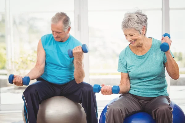 Couple holding dumbbells while exercising — Stock Photo, Image