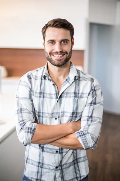 Man with arms crossed by kitchen counter — Stock Photo, Image