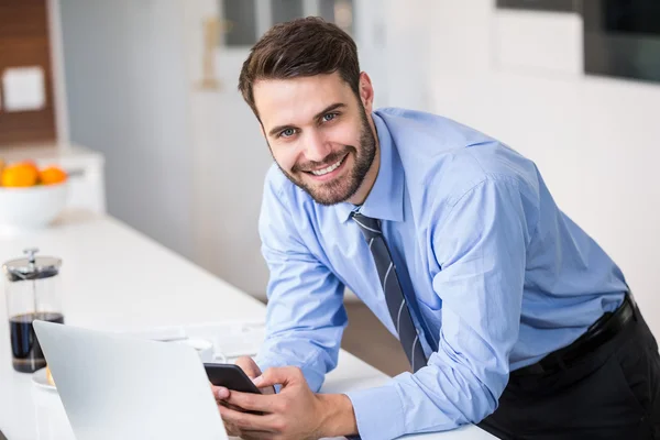 Empresário usando telefone celular em casa — Fotografia de Stock