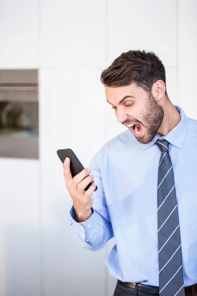 Businessman shouting while looking in phone — Stock Photo, Image