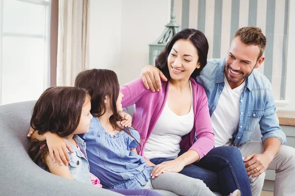 Parents sitting with children on sofa — Stock Photo, Image