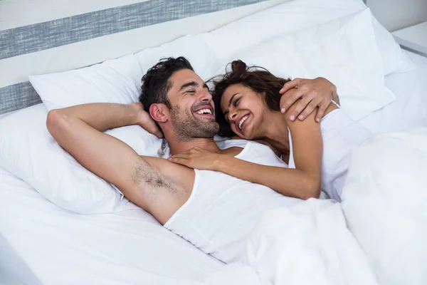 Счастливая пара отдыхает в постели — стоковое фото