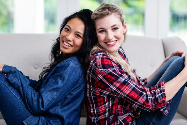 Vriendinnen zitten rug aan rug — Stockfoto