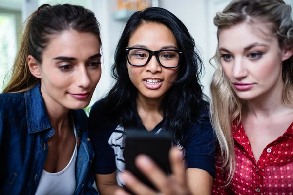 Amigos que buscan en el teléfono móvil — Foto de Stock