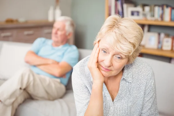 Tensed pareja de ancianos sentado en el sofá — Foto de Stock