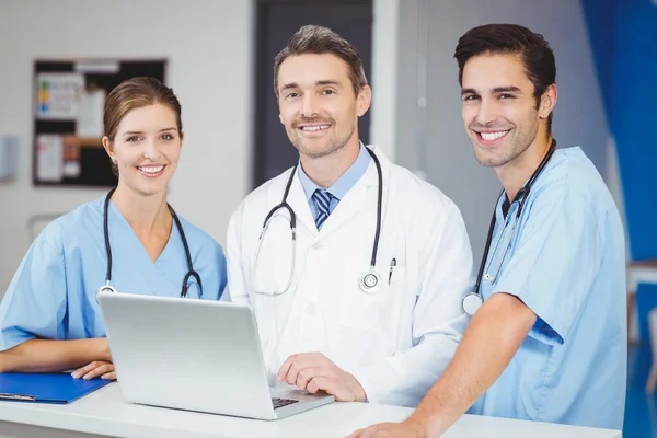 Médico e colegas com laptop — Fotografia de Stock