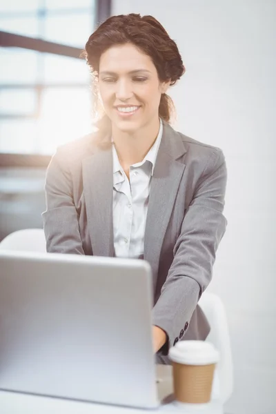 Affärskvinna med laptop på skrivbordet — Stockfoto
