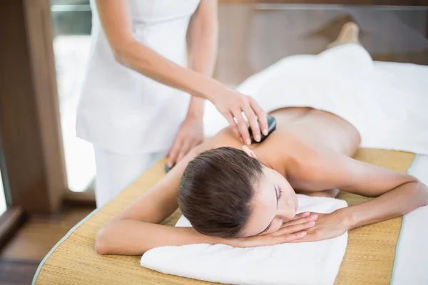Donna che riceve massaggio di pietra al centro benessere — Foto Stock