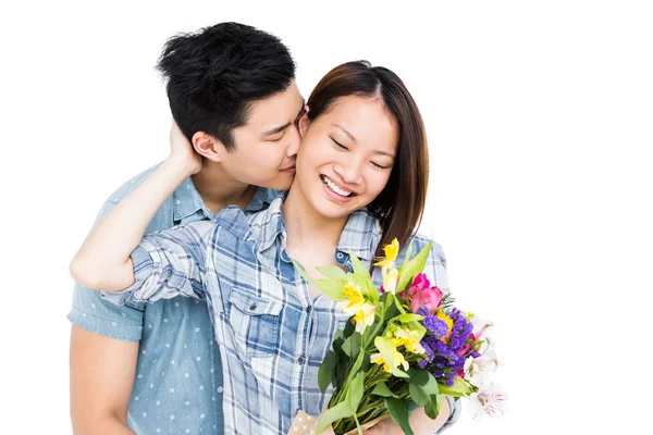 Мужчина целует женщину и дарит цветы — стоковое фото