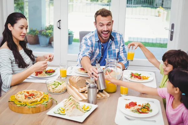 Familia sentada en la mesa de comedor con comida — Foto de Stock