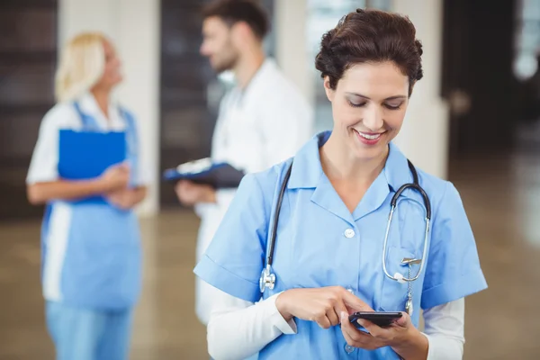 Sjuksköterska med på mobiltelefon — Stockfoto