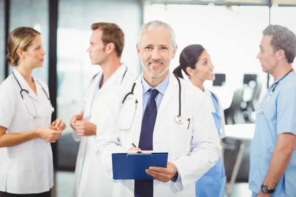 Doctor escribiendo en portapapeles — Foto de Stock