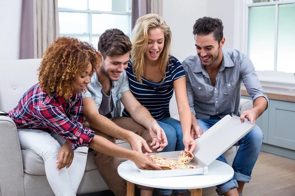 Amigos disfrutando de la pizza en casa — Foto de Stock