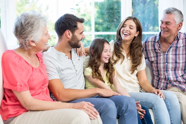 Kanepede otururken gülümseyen aile — Stok fotoğraf