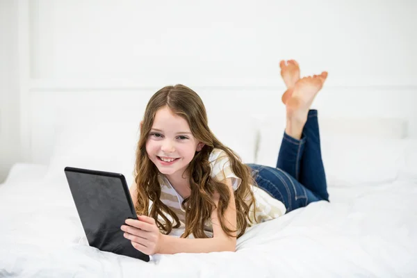 Chica usando tableta digital en la cama — Foto de Stock
