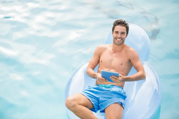 Handsome man relaxing on inflatable ring — Stock Photo, Image