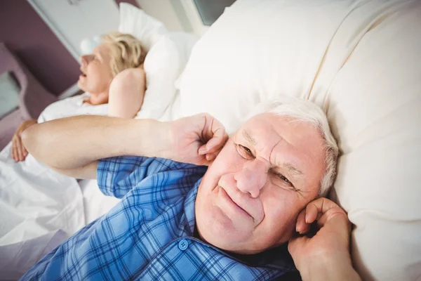 Man die betrekking hebben op oren van snurken vrouw — Stockfoto