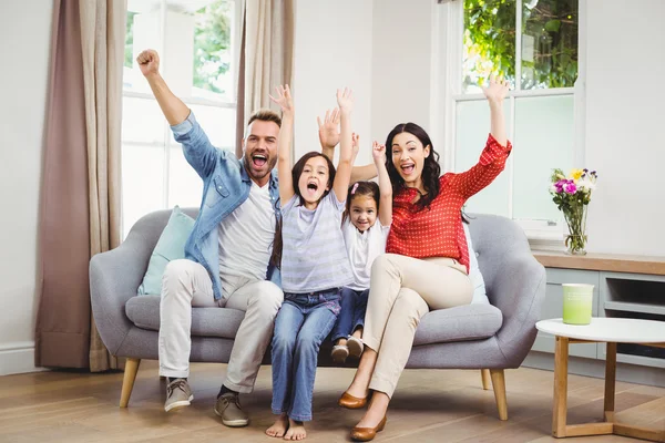 Familjen jublar medan placeringen på soffa — Stockfoto