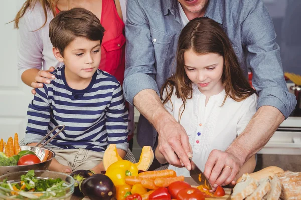 Far skära grönsaker med fru och barn — Stockfoto