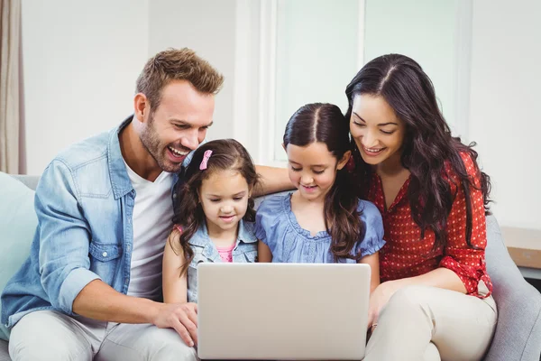 Aile gülümseyen ve içinde laptop arıyorum — Stok fotoğraf