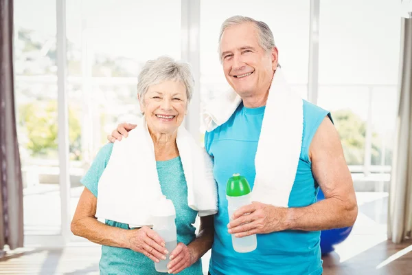 smiling senior couple holding bottle