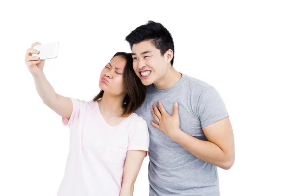 Пара, делающая селфи на смартфоне — стоковое фото