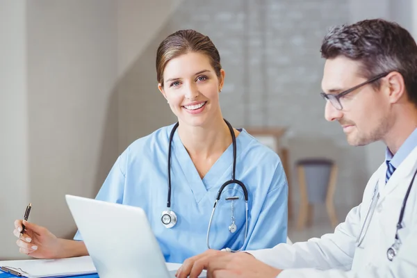 Médico sentado na mesa com colega — Fotografia de Stock