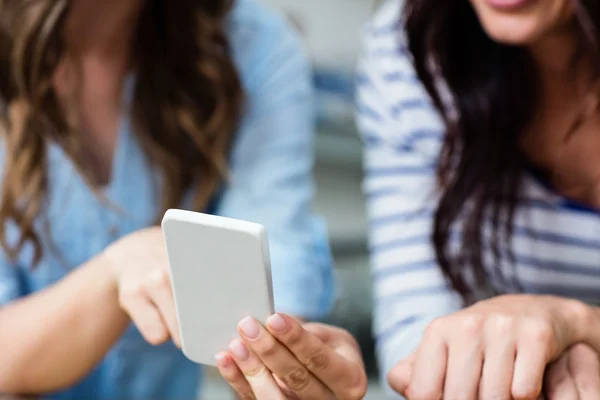 Amigos do sexo feminino usando telefone móvel — Fotografia de Stock