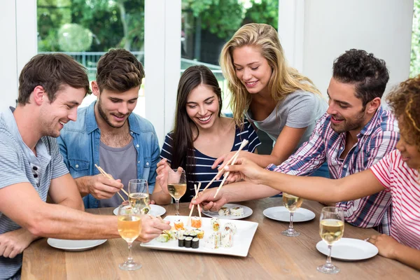 Amigos disfrutando del vino y sushi —  Fotos de Stock