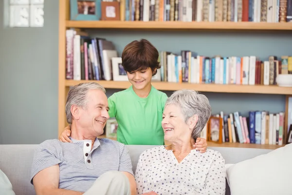Kleinzoon met grootouders in woonkamer — Stockfoto