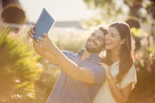 Leende par att klicka selfie med digitala tablett — Stockfoto