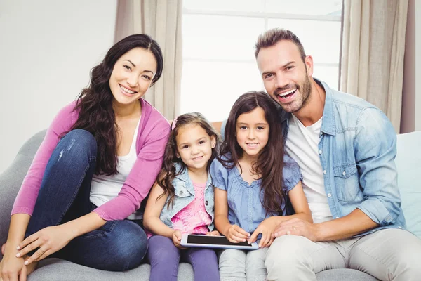 Familie met tablet pc zittend op de Bank — Stockfoto