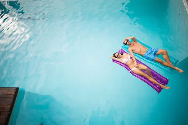 Casal relaxante em jangadas infláveis — Fotografia de Stock