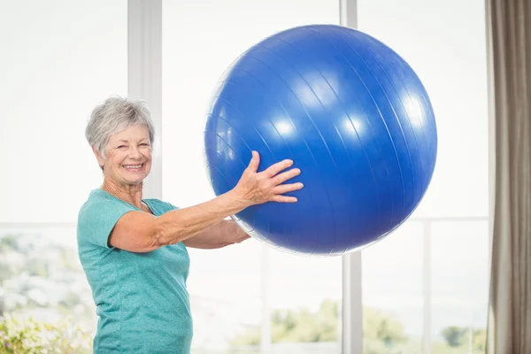 Sorrindo sênior mulher segurando bola de exercício — Fotografia de Stock