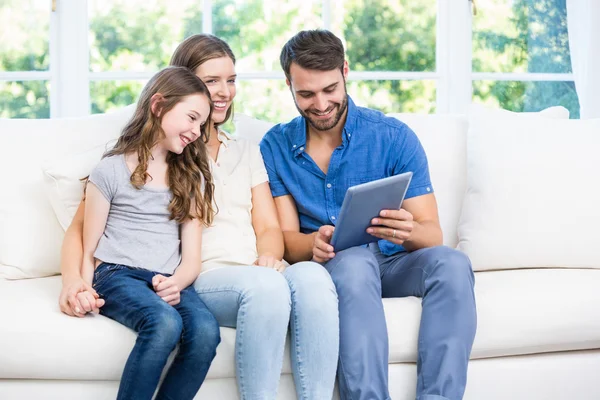 Dijital tablet ile kanepede oturan aile — Stok fotoğraf