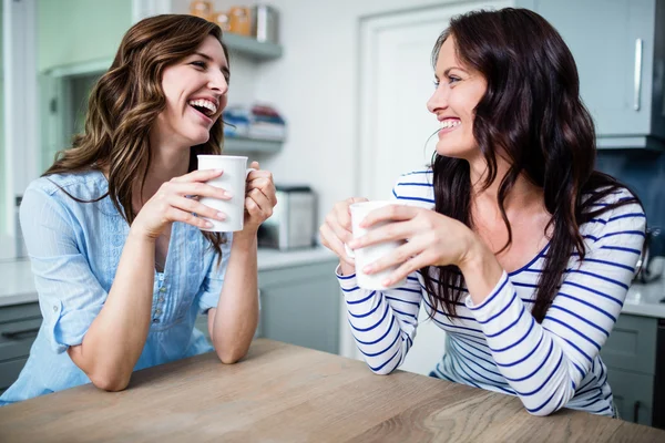 Amigos femininos segurando canecas de café — Fotografia de Stock